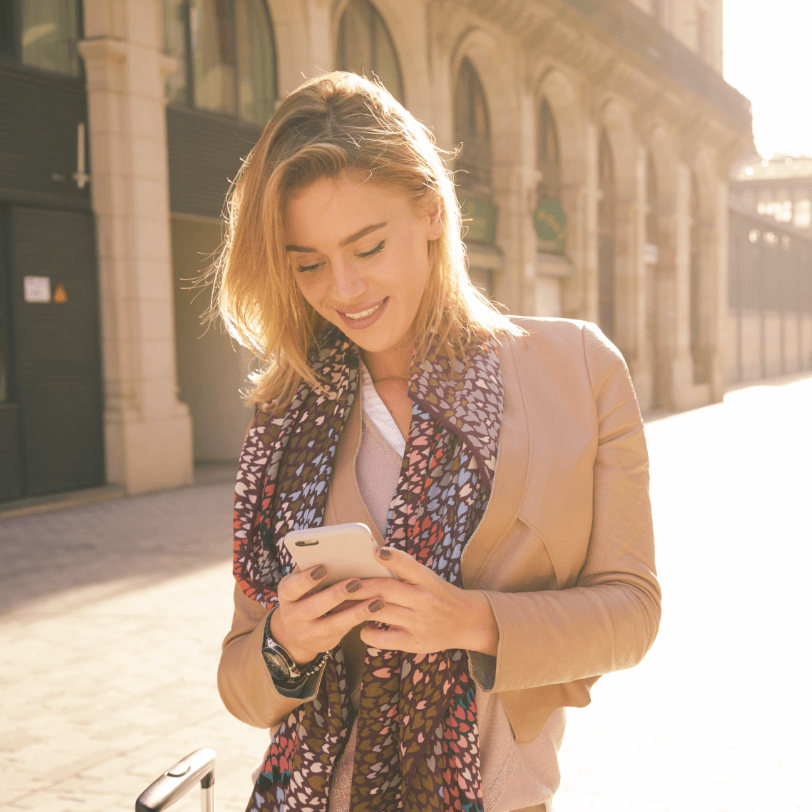 Woman smiling whilst looking at her mobile phone