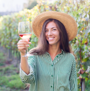 Woman in vineyard holding a glass of wine
