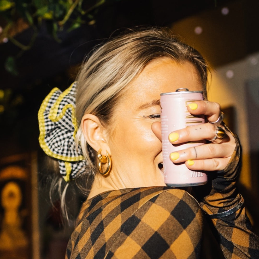Woman holding canvino rose infront of her face.